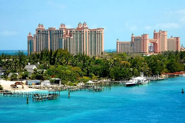 Bahamas cruise deal highlighting a ship gliding through turquoise waters with views of palm-fringed islands, white-sand beaches, and tropical sunshine