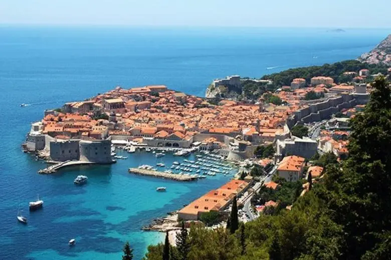 Mediterranean cruise deal featuring a ship sailing past sun-kissed coastlines, ancient ruins, and iconic ports from Italy to Greece and beyond