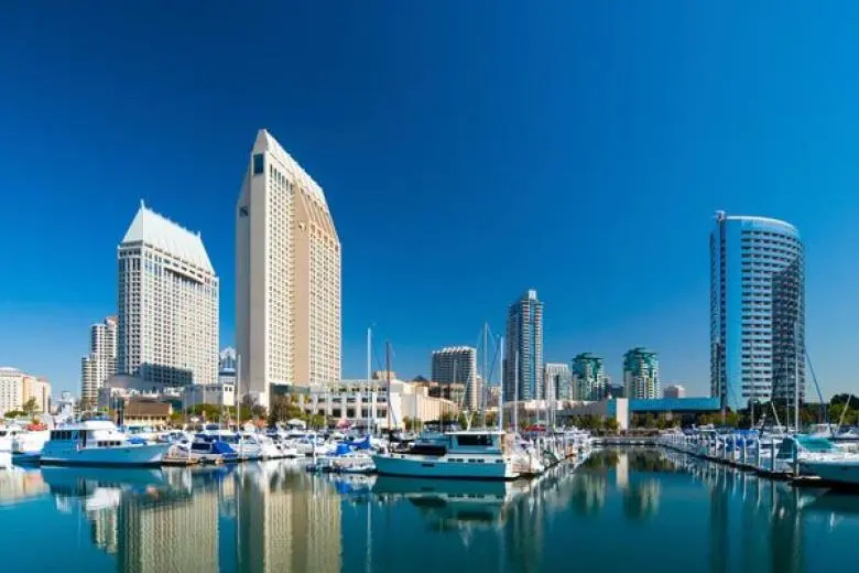San Diego cruise deal featuring a ship sailing along the Southern California coast with views of sun-soaked beaches, the downtown skyline, and the historic harborfront