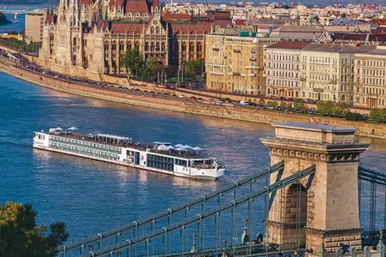 River cruise deal showcasing a ship gliding through scenic waterways with views of charming villages, vineyard-covered hills, and historic European landmarks